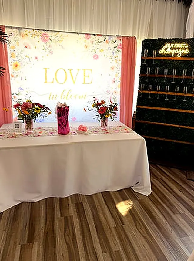 Champagne wall beside a floral Love in Bloom backdrop