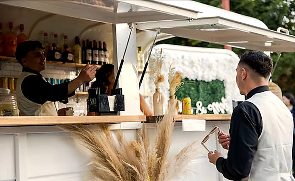 Bartenders serving guests from the trailer